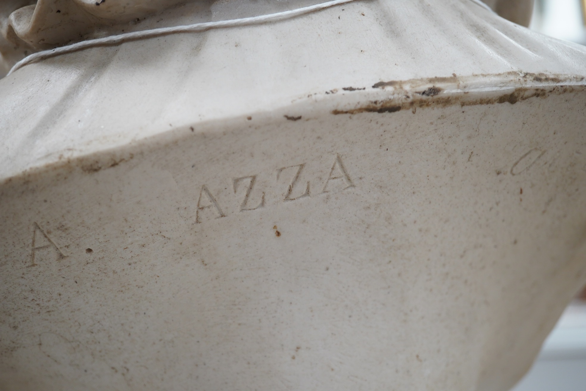 A composition bust of a boy on stand in a hat, ruff and pom-pom buttoned top, inscribed ‘A Azza’, 55cm high. Condition - fair